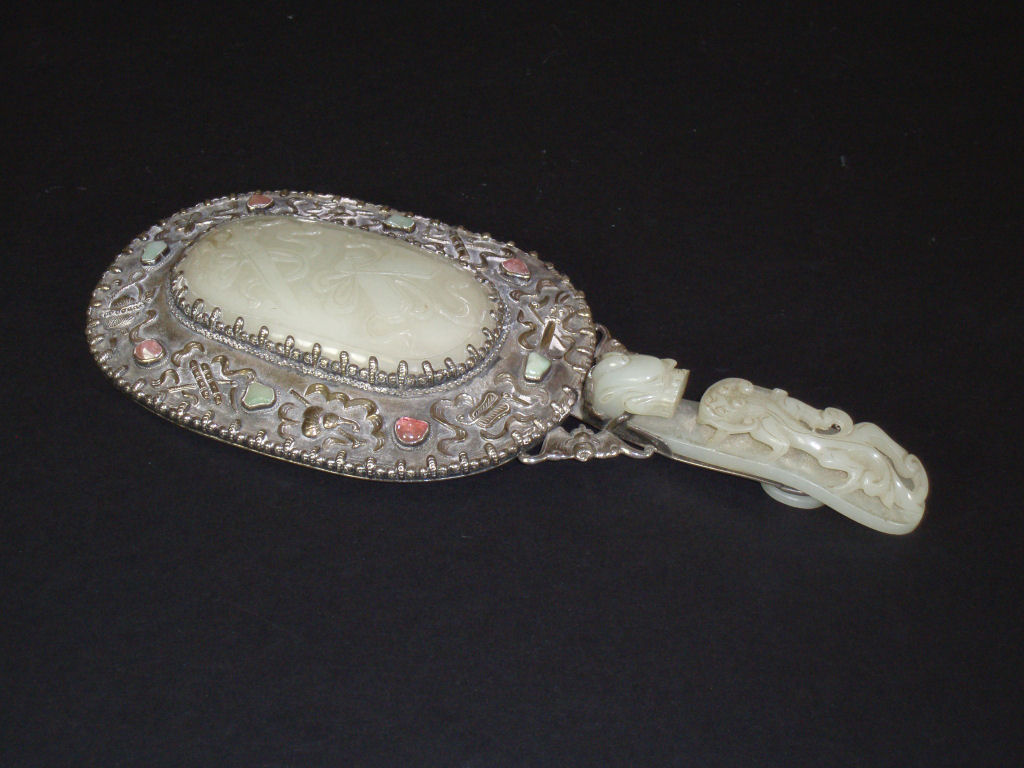 A Chinese white metal and jade hand mirror