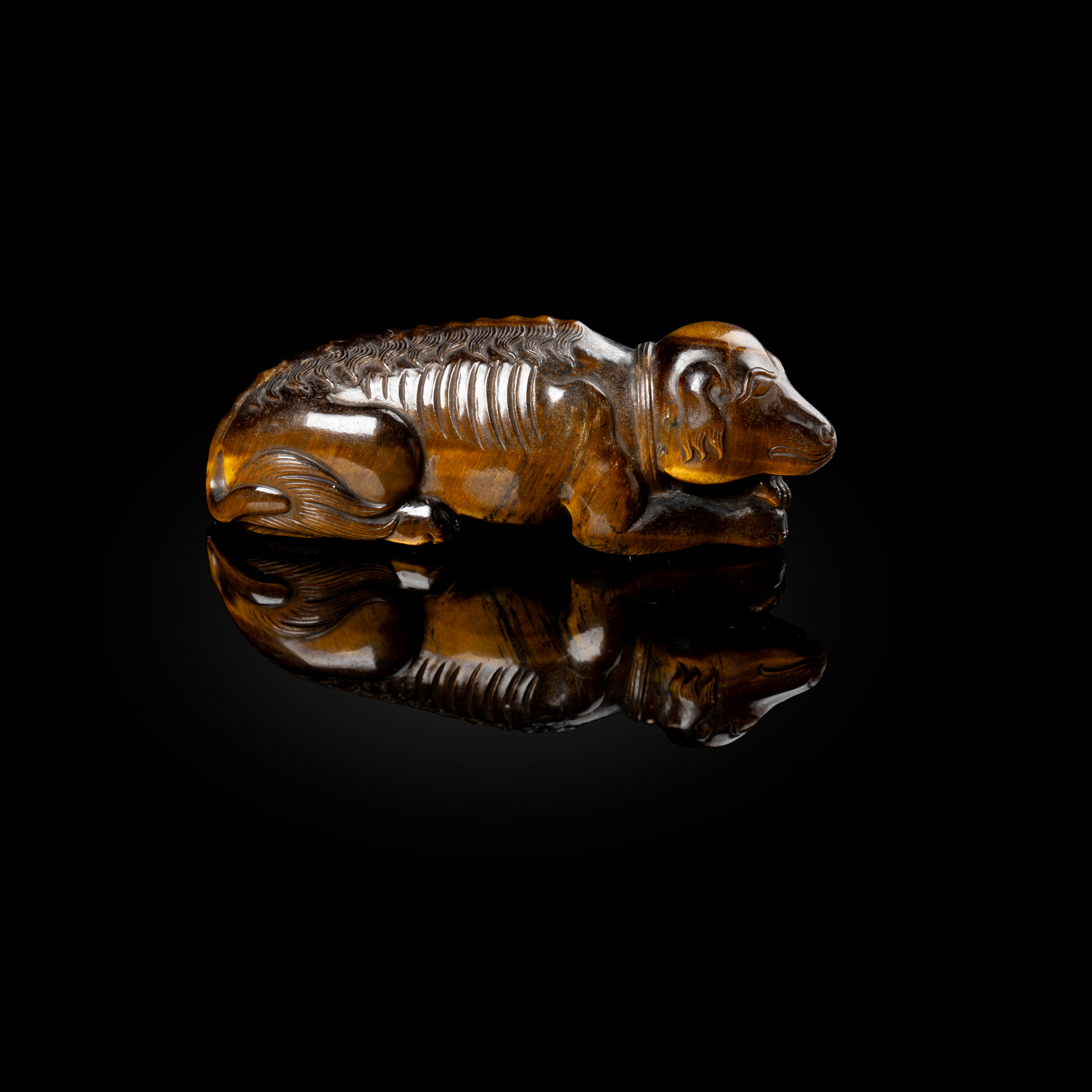 CHINESE TIGER'S EYE CARVING OF A RECUMBENT DOG