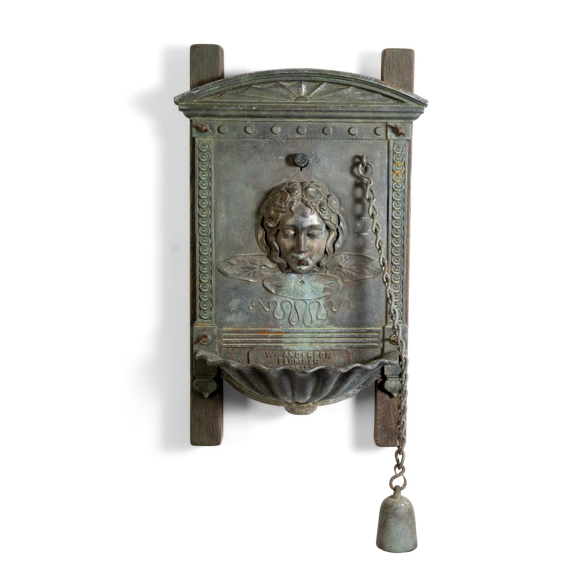 A BRONZE WALL MOUNTED DRINKING FOUNTAIN