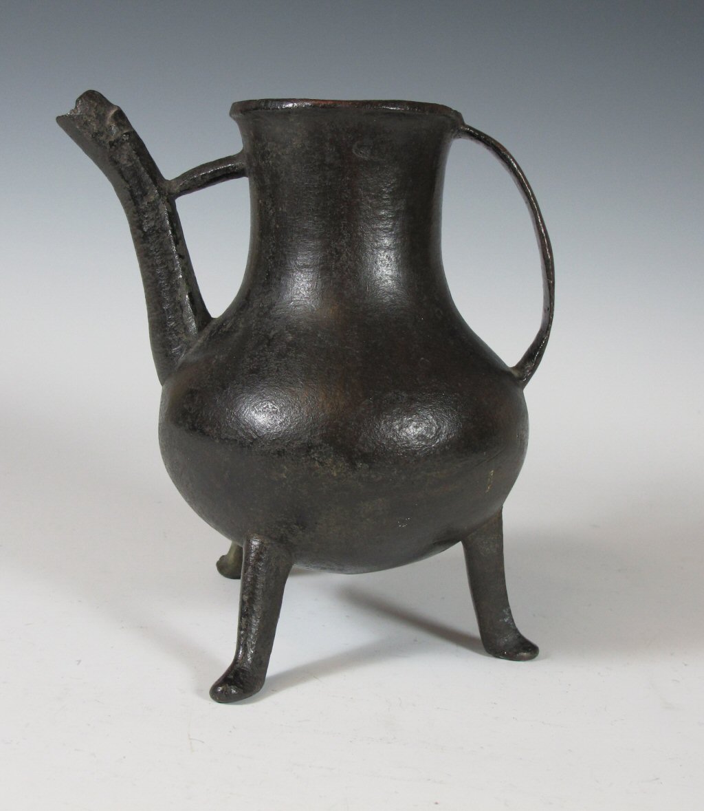 A medieval bronze tripod ewer