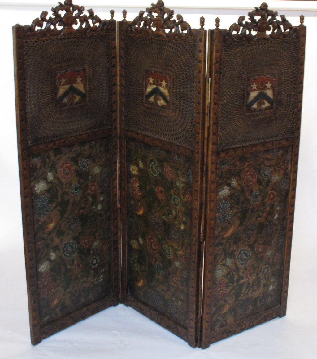 A late Victorian carved oak and painted leather three panel draught screen In the Carolean manner