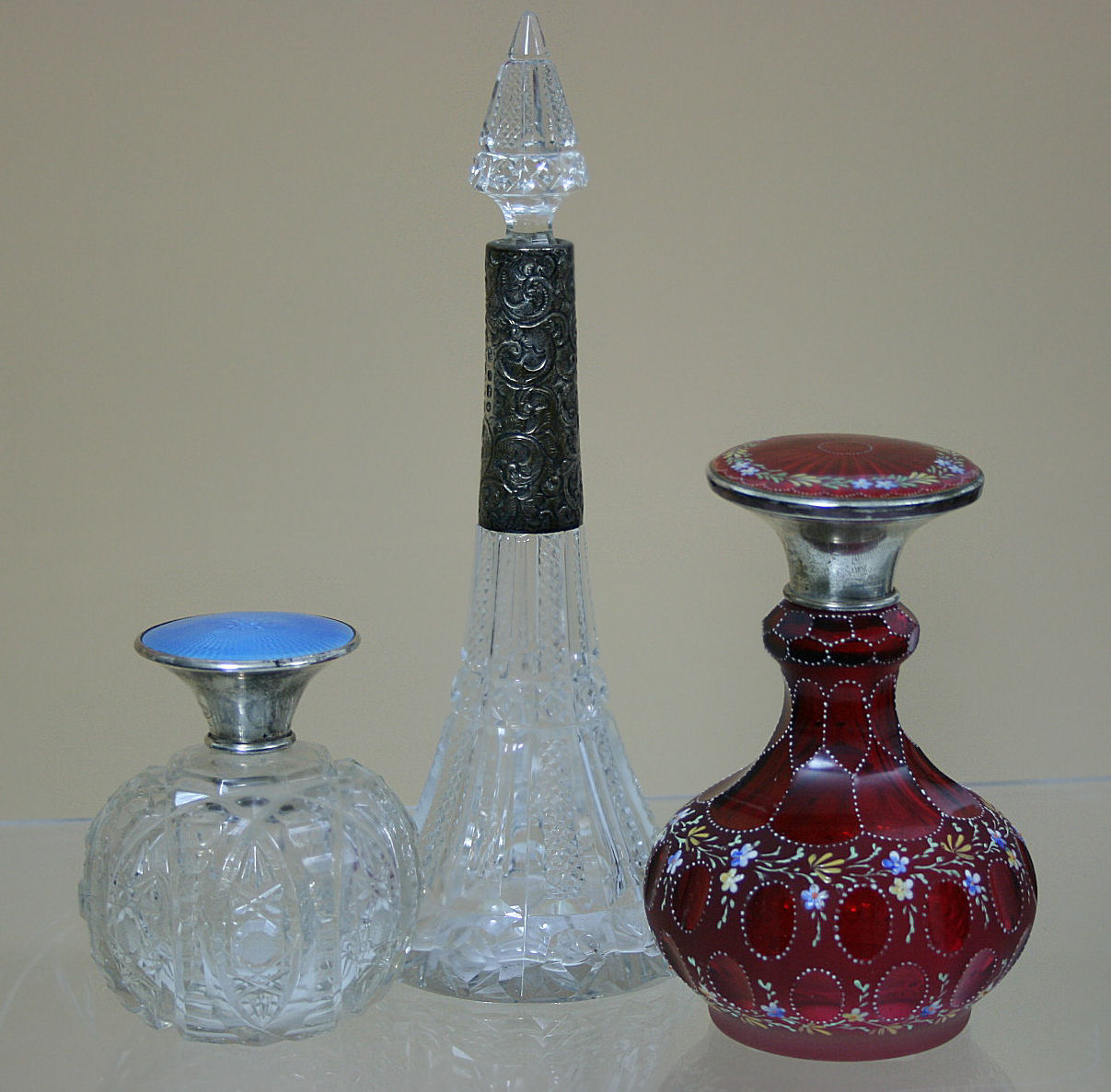 A enamelled ruby glass and silver lidded table scent bottle