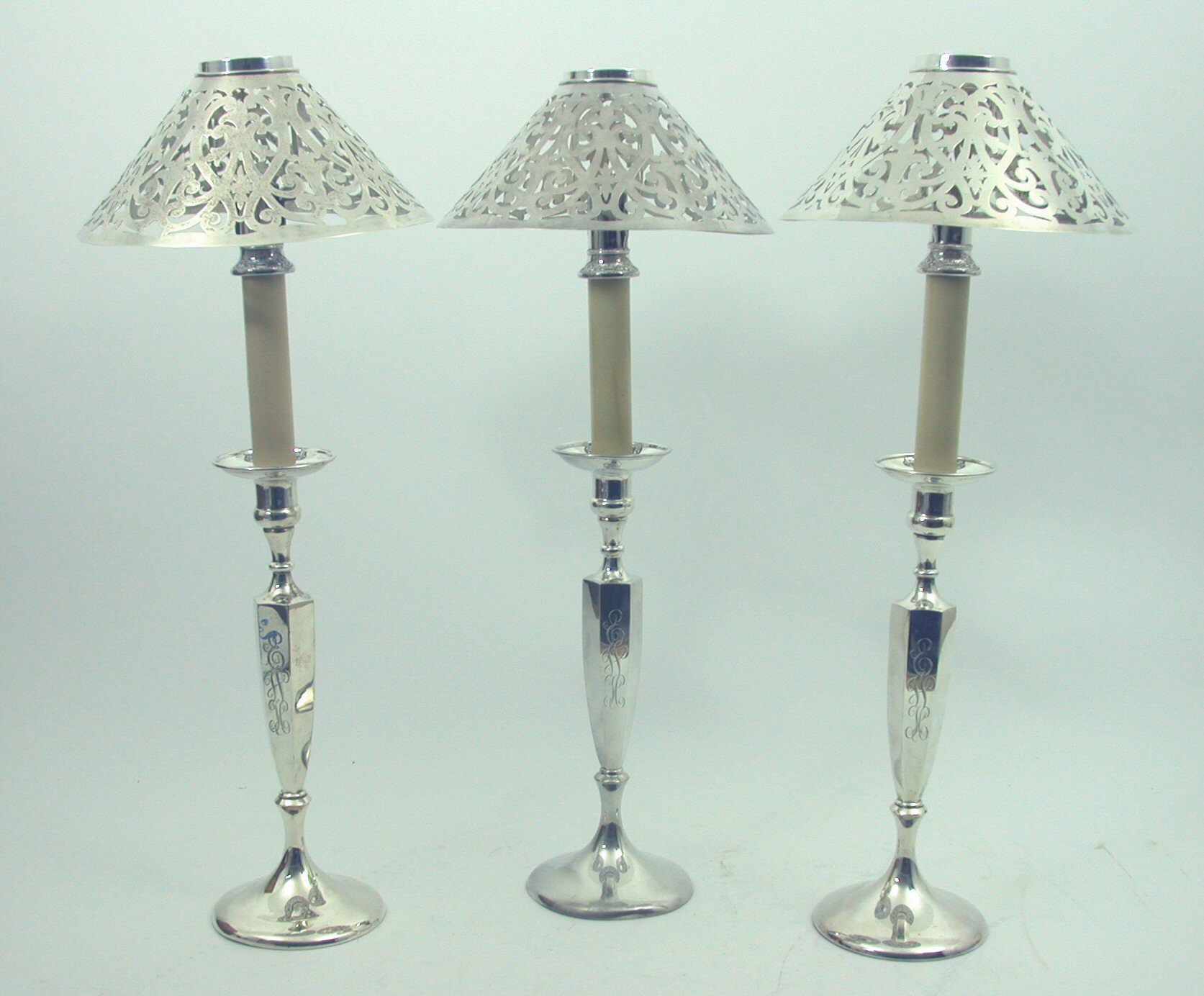 Shreve & Co. - three American silver candlesticks,