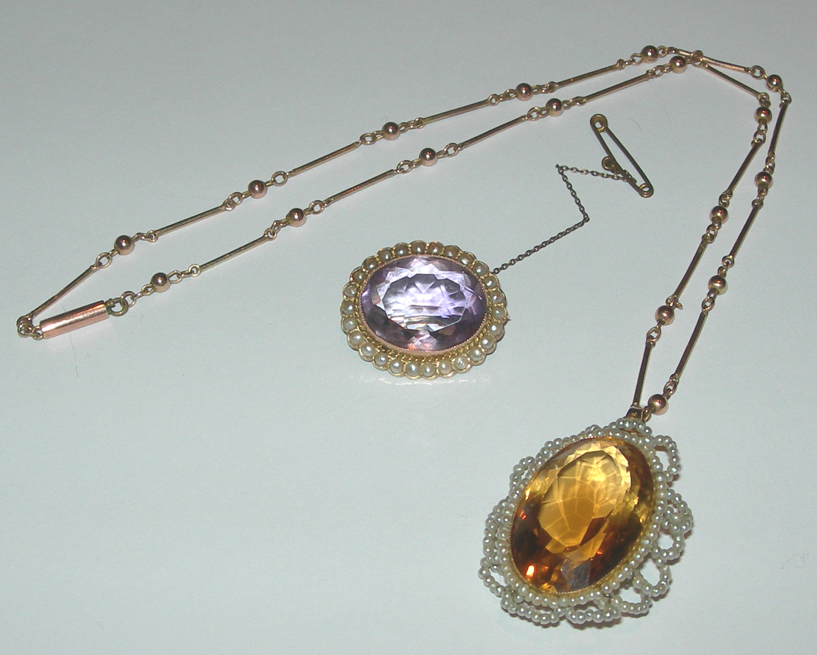 A large oval cut citrine and seed pearl set pendant,