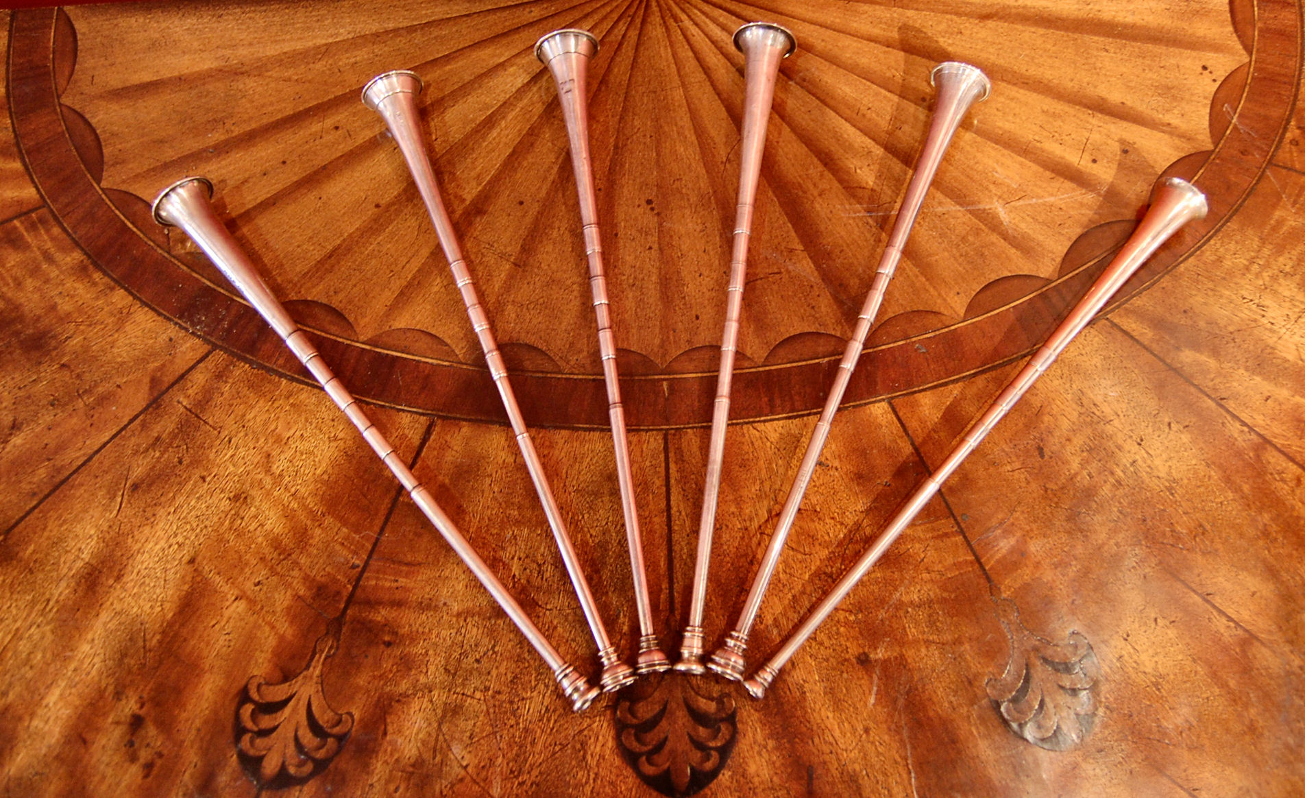 A matched set of slender silver hunting horns