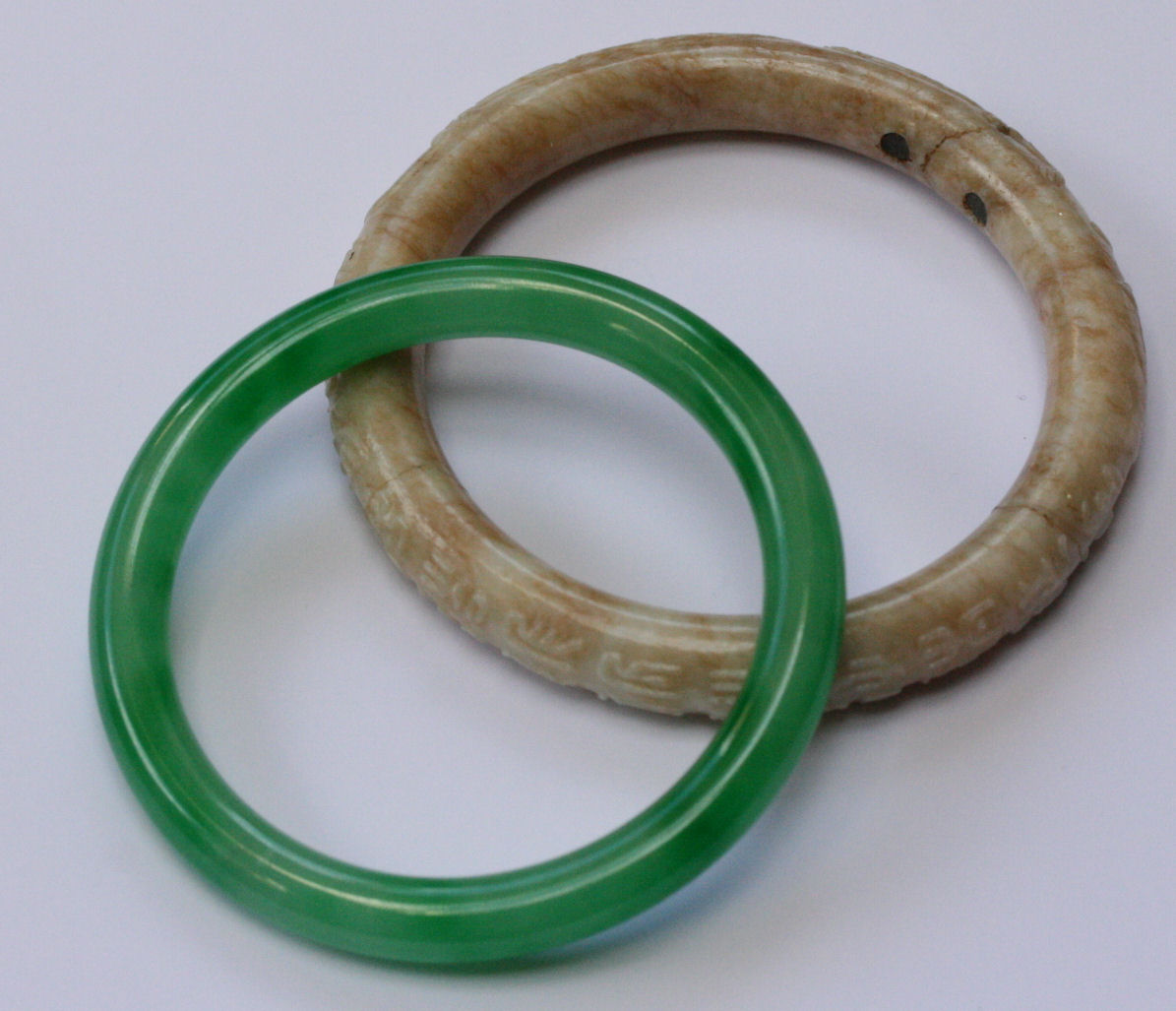 A jadeite bangle and another carved bangle