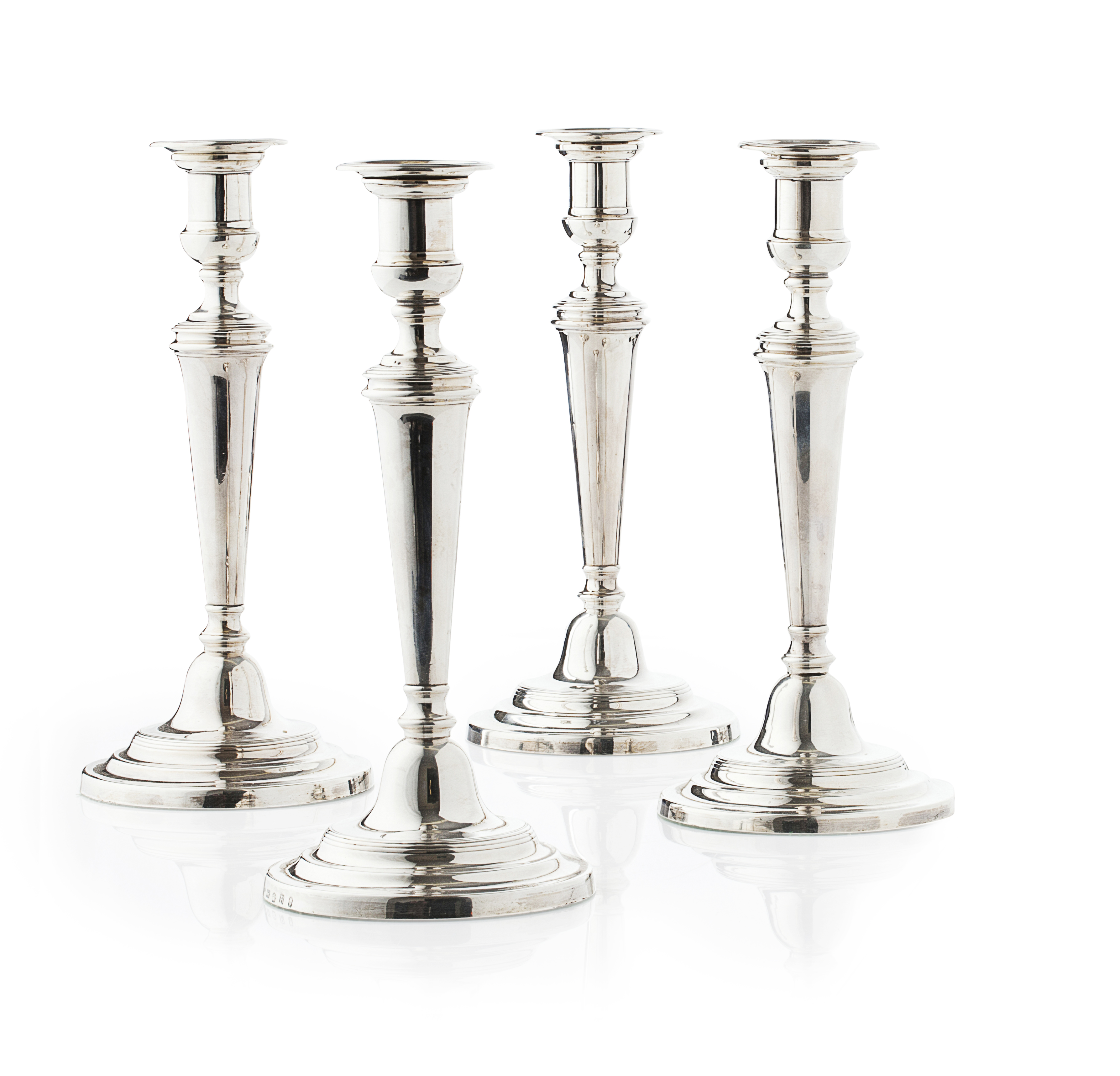A set of four George III plain silver table candlesticks
