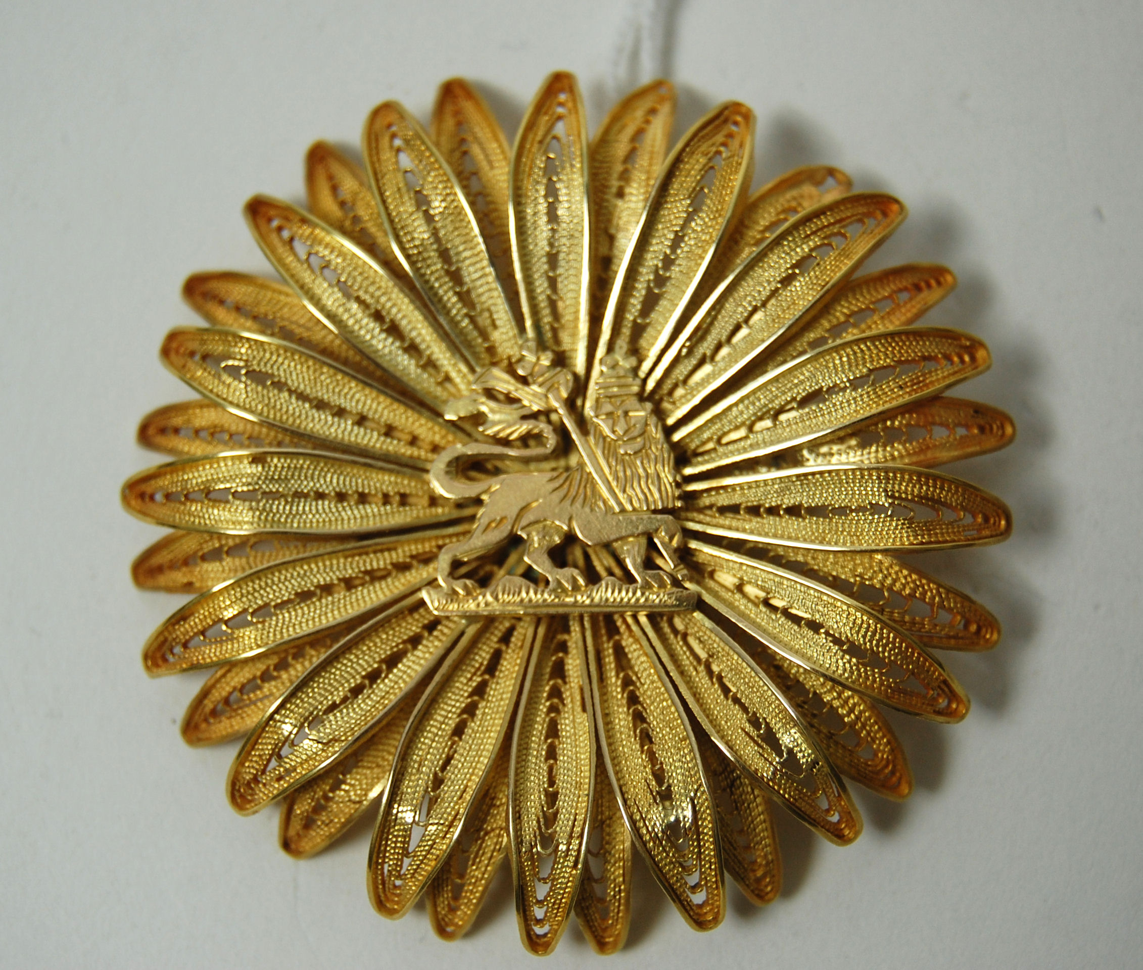 A circular floral brooch/pendant,