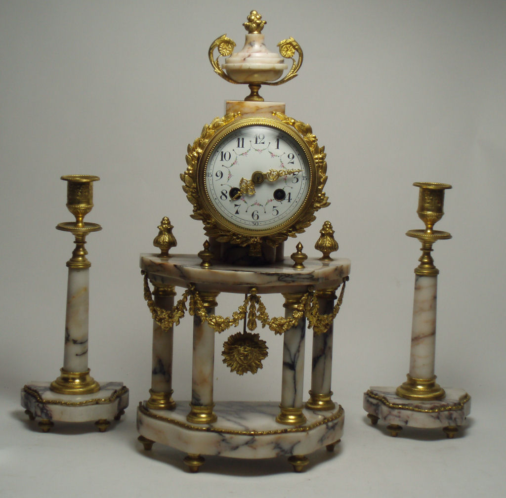 A late 19th century French gilt metal and marble clock garniture In the Empire style