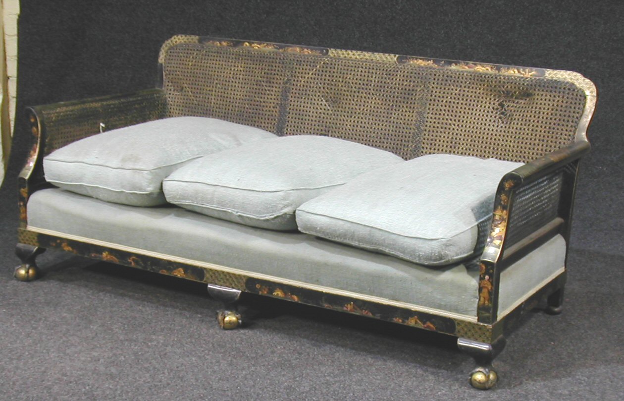 An early 20th century black bergere suite,