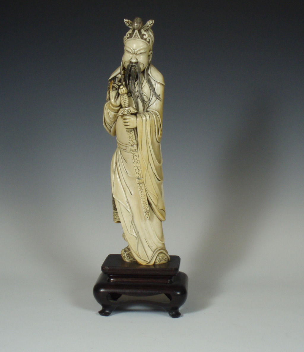 A Japanese ivory figure of a man with a sword, Meiji or Taisho period