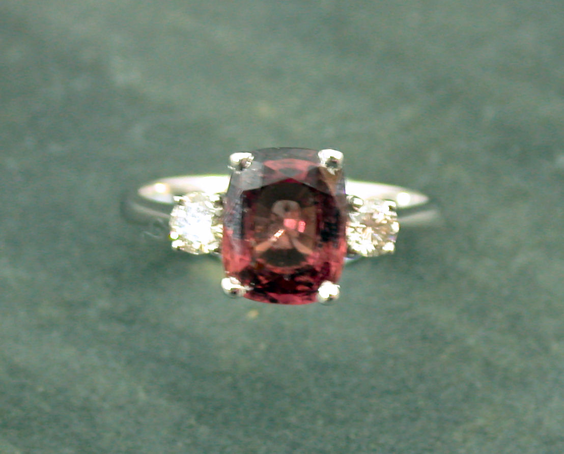 A reddish-brown sapphire and diamond three-stone ring,