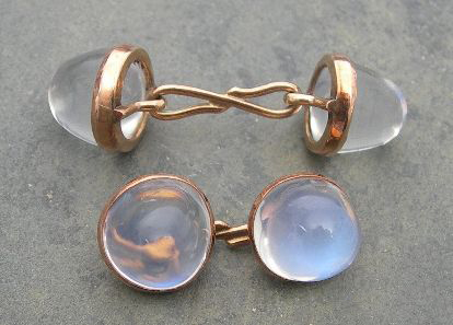 A pair of rose gold mounted moonstone cufflinks