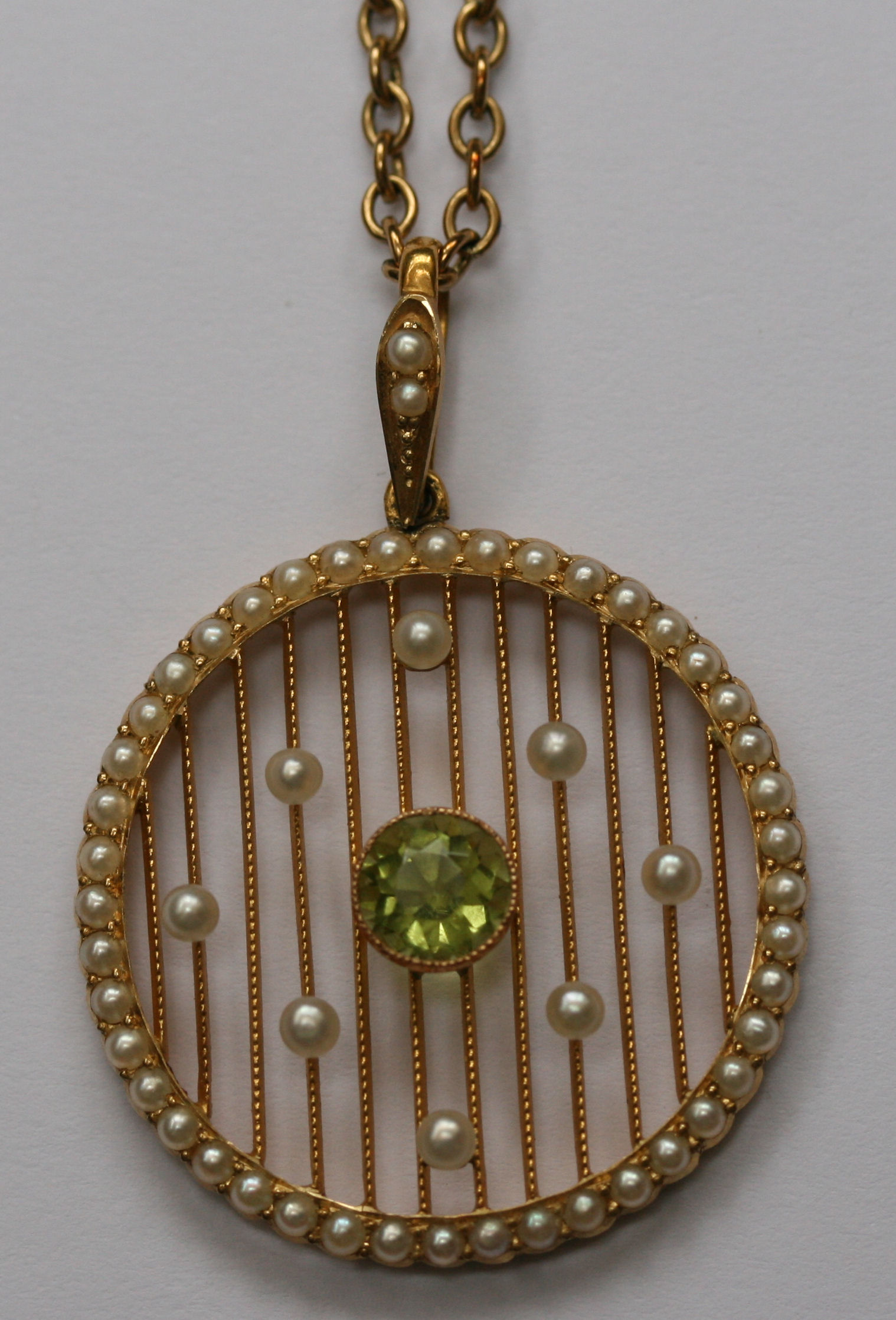 An attractive early 20th century gold, pearl and peridot pendant