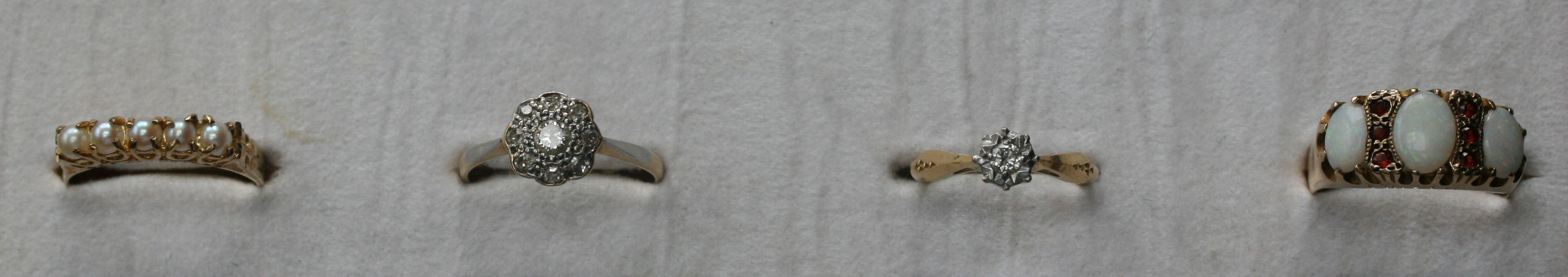 A group of four gold, diamond, pearl, and gem set rings