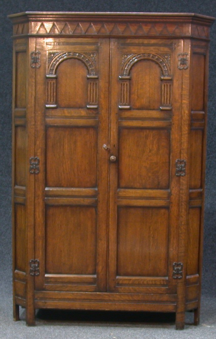 A reproduction oak Jacobean two door oak hall robe,
