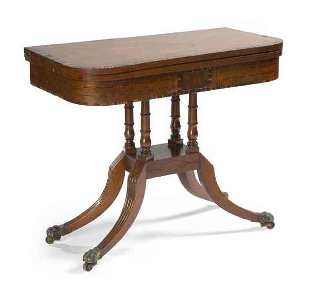 A Regency period mahogany and zebrawood crossbanded foldover games table