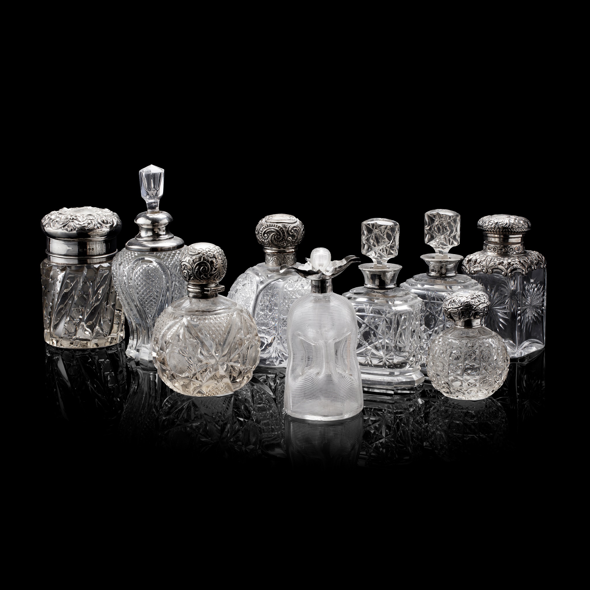 COLLECTION OF SILVER MOUNTED CUT GLASS SCENT BOTTLES AND JARS