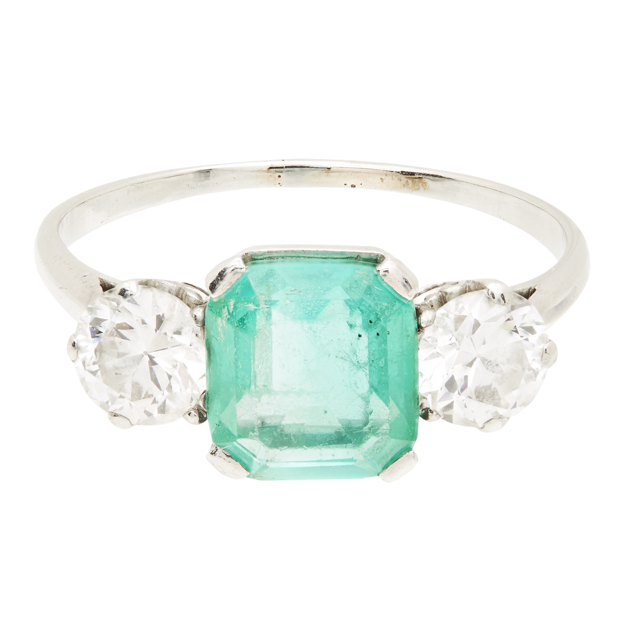 An emerald and diamond set three stone ring