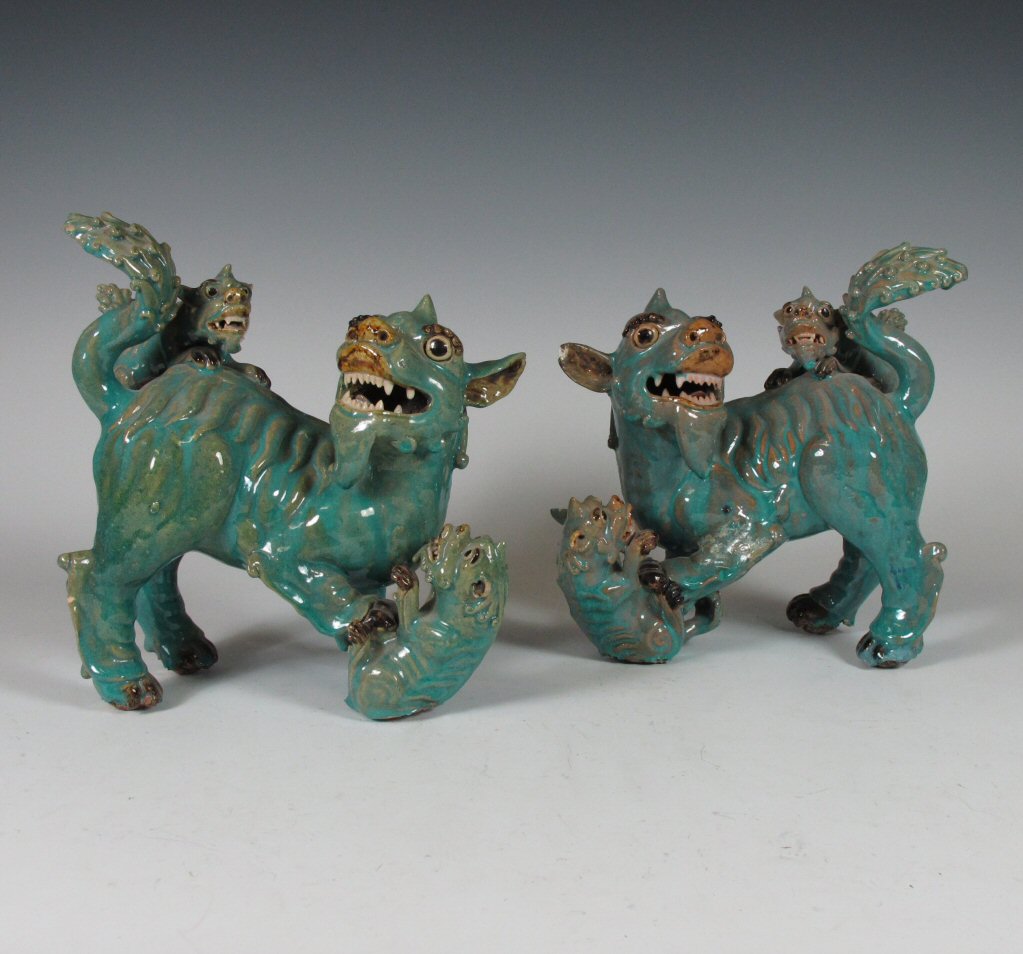 A pair of early 20th century Chinese turquoise glazed lion dogs