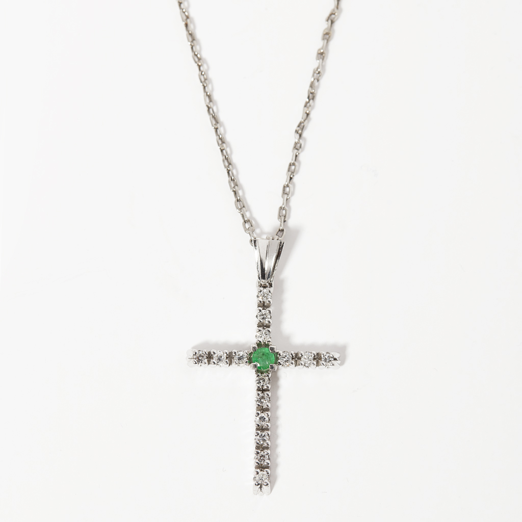 A diamond and emerald set pendant cross