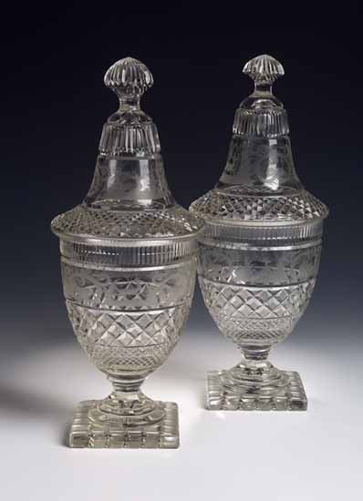 A matched pair of cut glass urns and covers