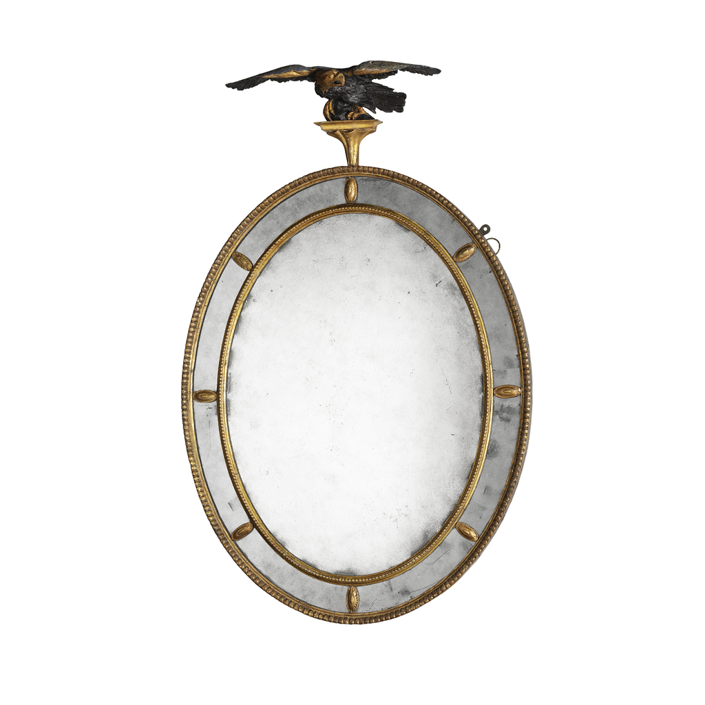 LATE GEORGE III OVAL GILTWOOD AND EBONISED MIRROR