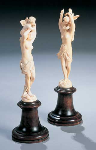 A pair of carved ivory figure groups