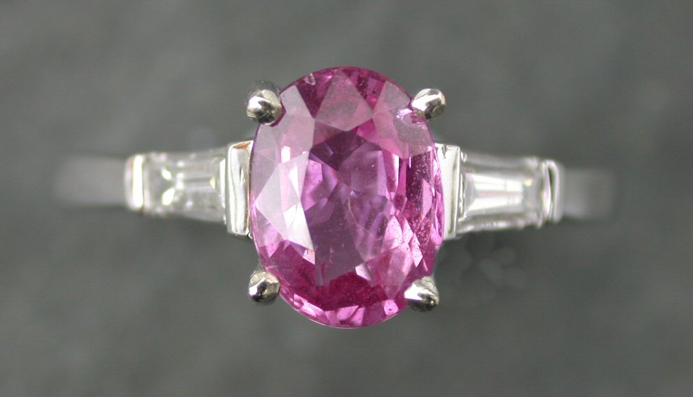 A pink sapphire and diamond three stone ring,