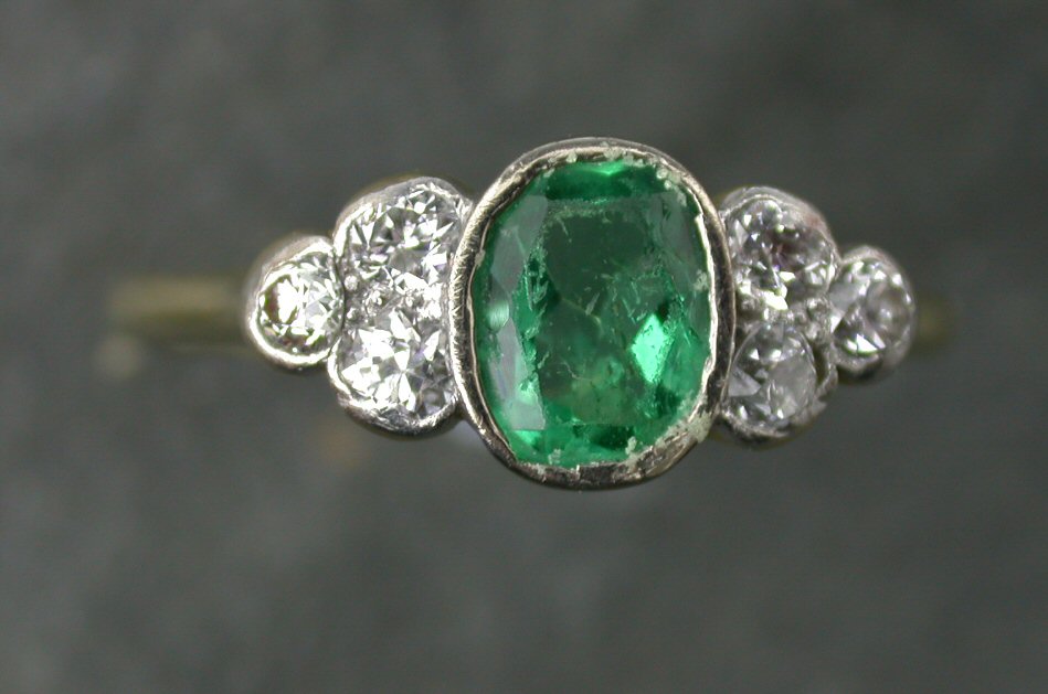 An 18ct gold mounted emerald and diamond ring,