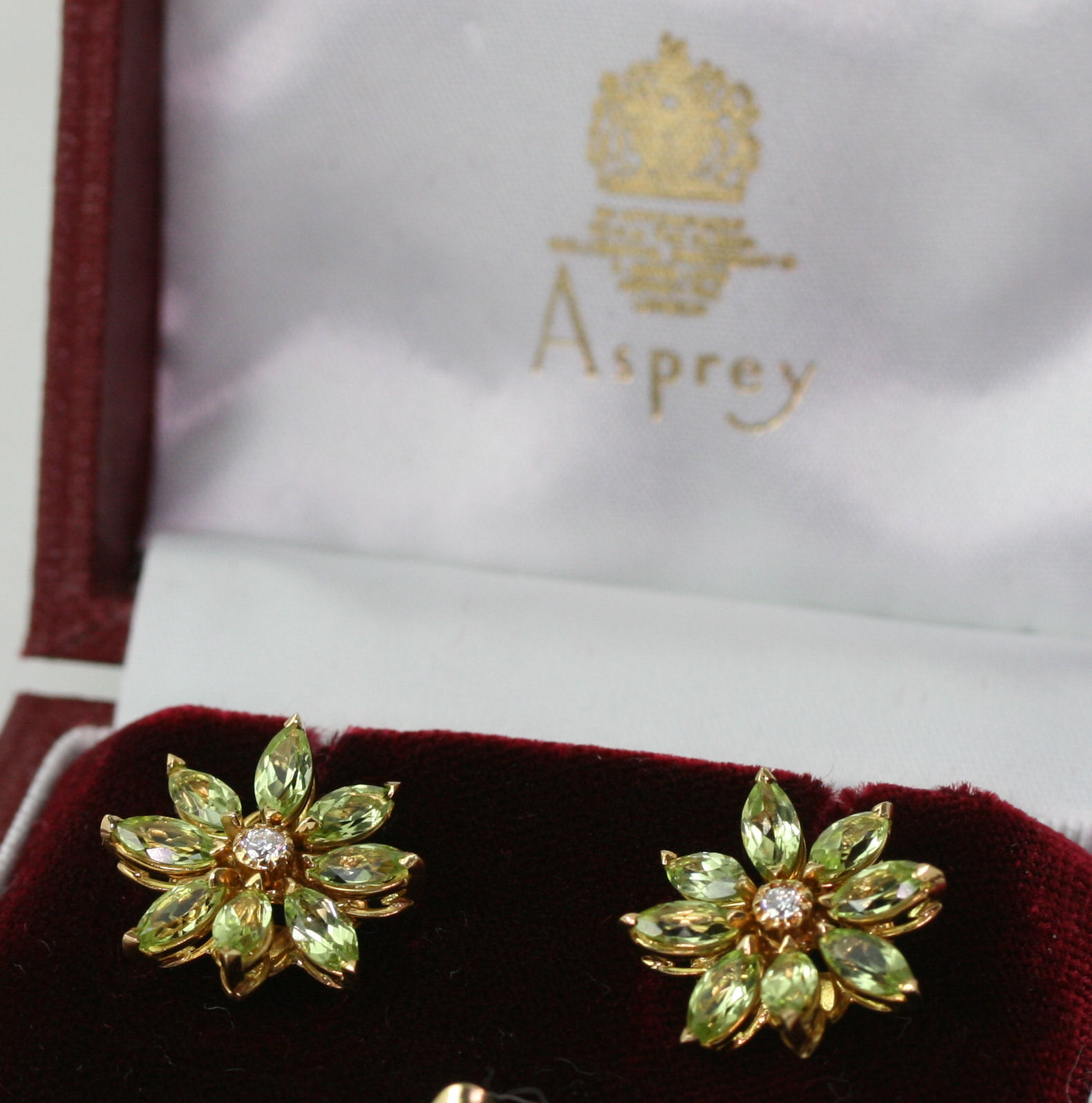 ASPREY - a pair of contemporary 18ct gold mounted diamond and peridot set earrings,