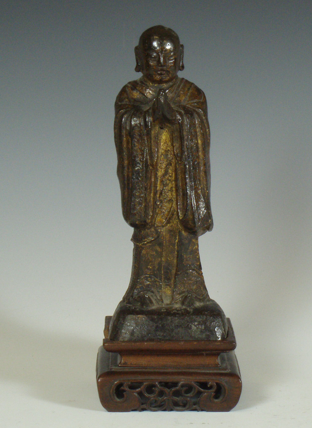 A Chinese bronze standing figure of a Buddhist monk in prayer, Ming dynasty or later
