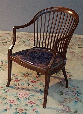 An Edwardian mahogany and satinwood inlaid comb back tub chair
