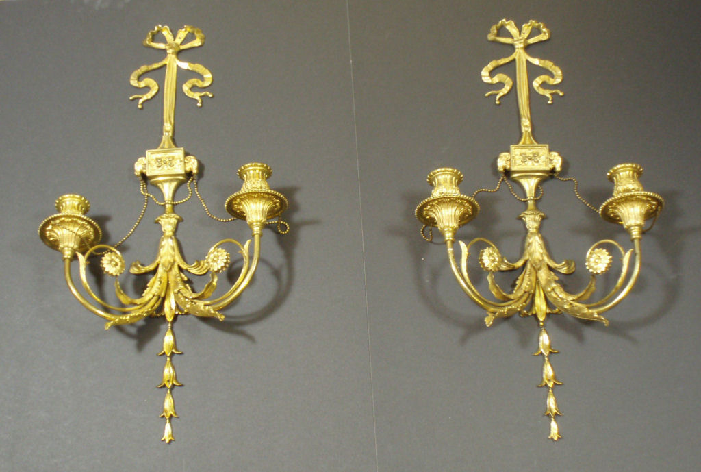 A pair of late 19th/early 20th century gilt bronze wall lights In the Louis XVI style