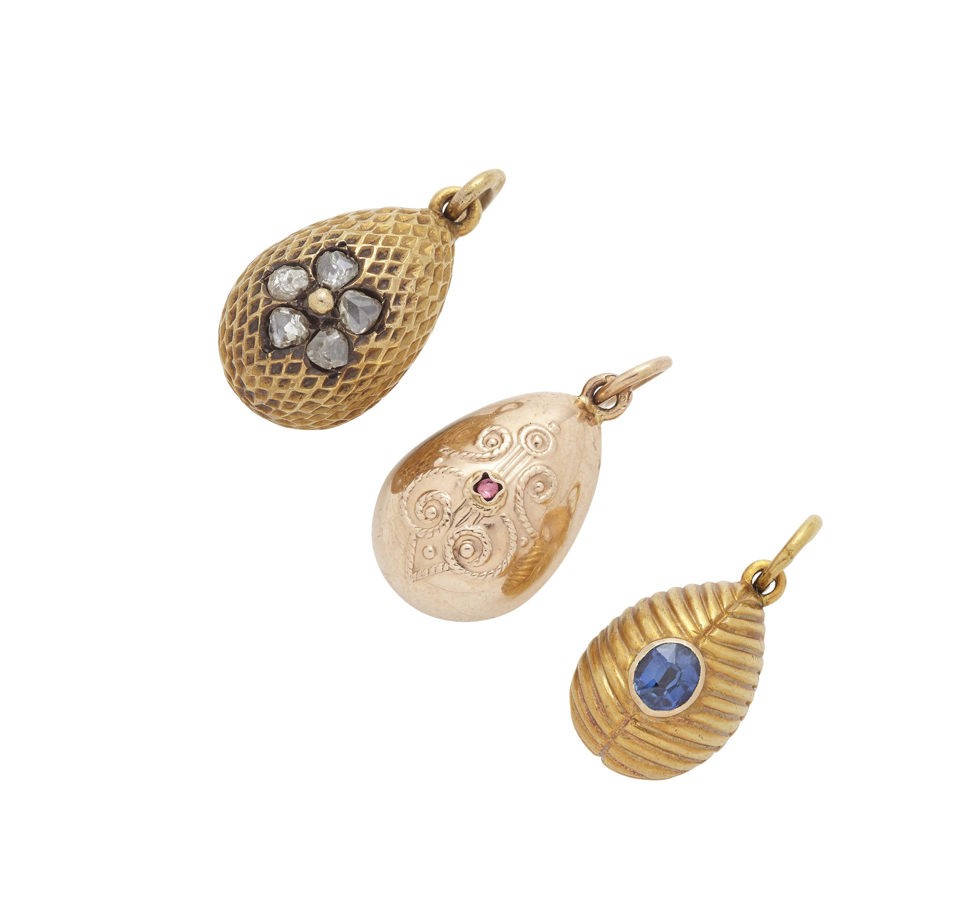 A group of three Russian gold and gem set egg pendants
