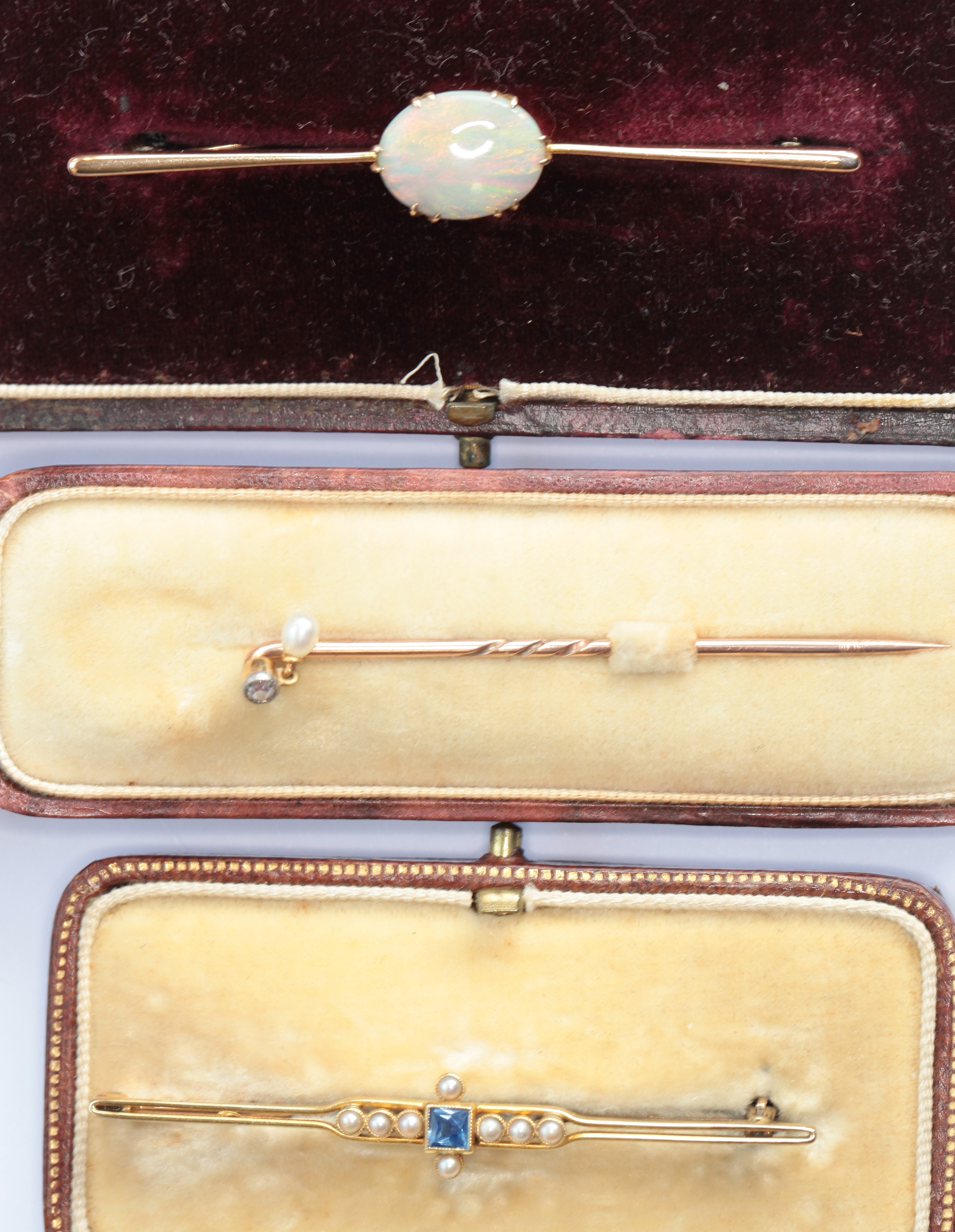 Two gem set bar brooches and a stick pin