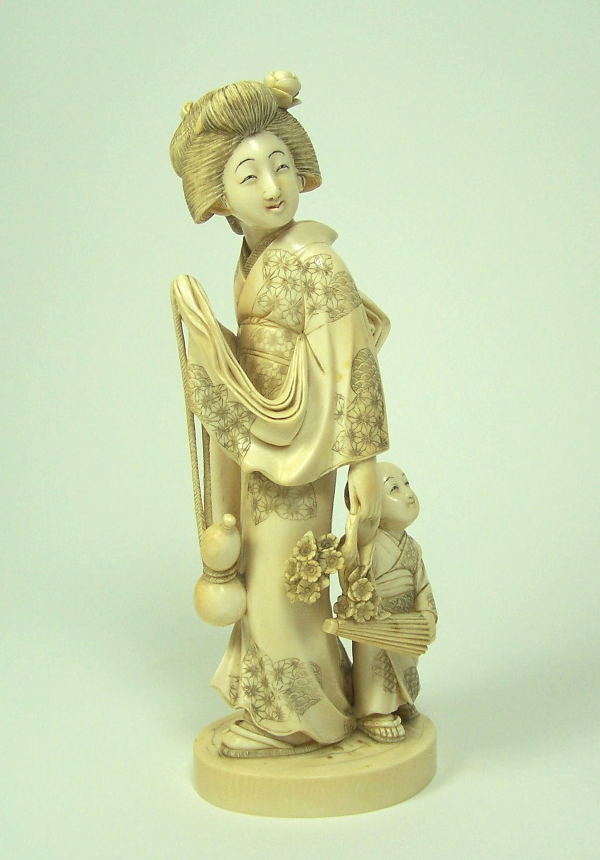 A large Japanese ivory figure of a bejin and child, Meiji or Taisho period