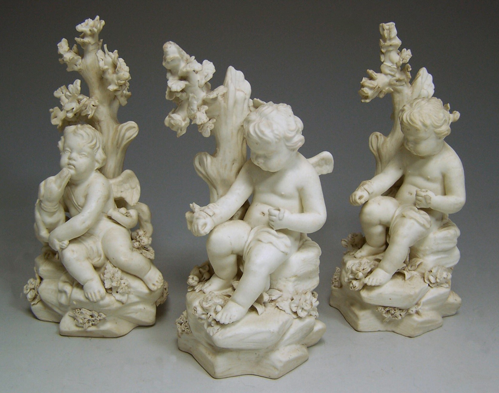 Three 18th century Derby biscuit figures of putti