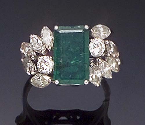 A platinum mounted emerald and diamond ring,