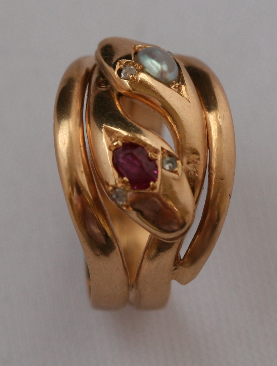 A ruby and pearl set double snake ring