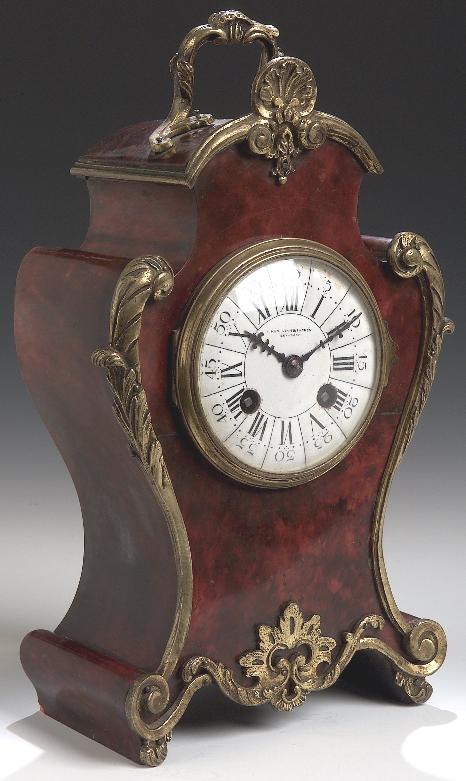 An Edwardian tortoiseshell and brass mantel clock