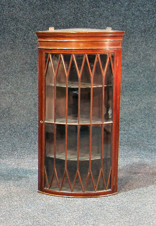 An Edwardian mahogany bowfront corner cabinet