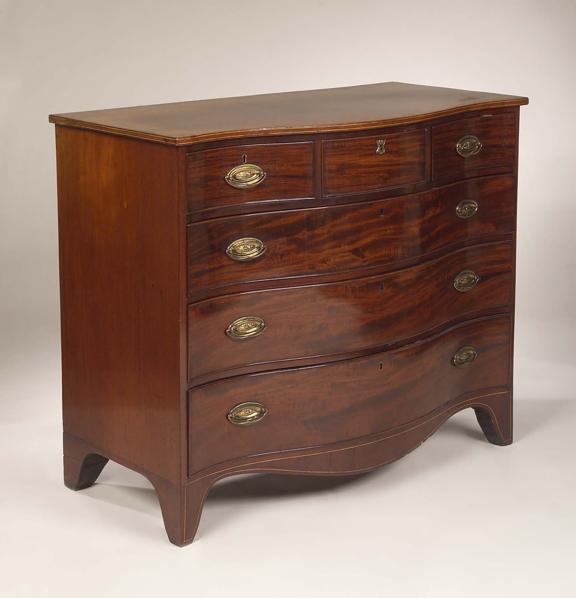 An early 19th century mahogany serpentine chest of drawers,