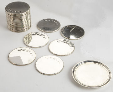 A set of twenty-two silver mounted wine coasters
