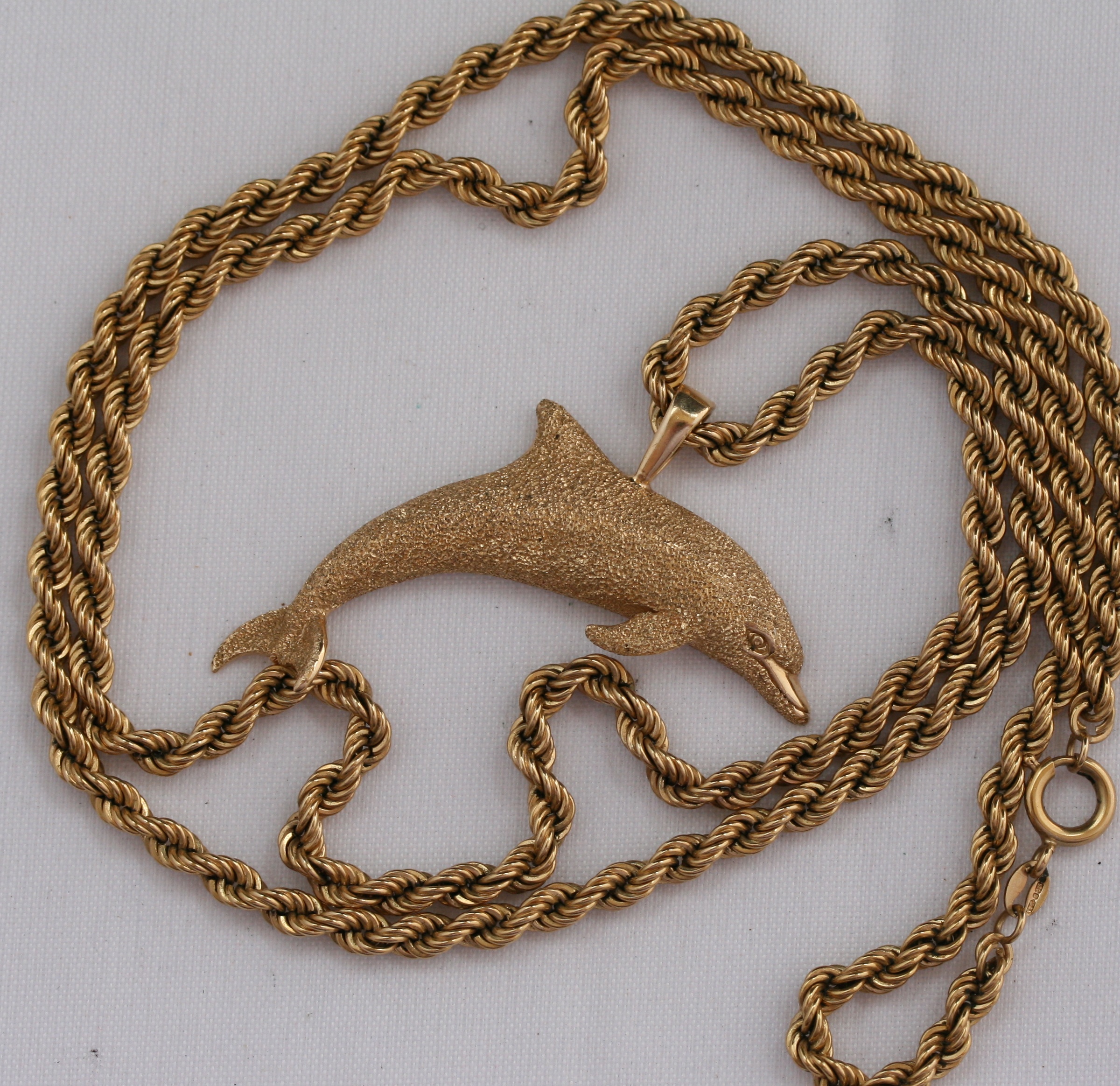 A dolphin design pendant with rope twist link chain
