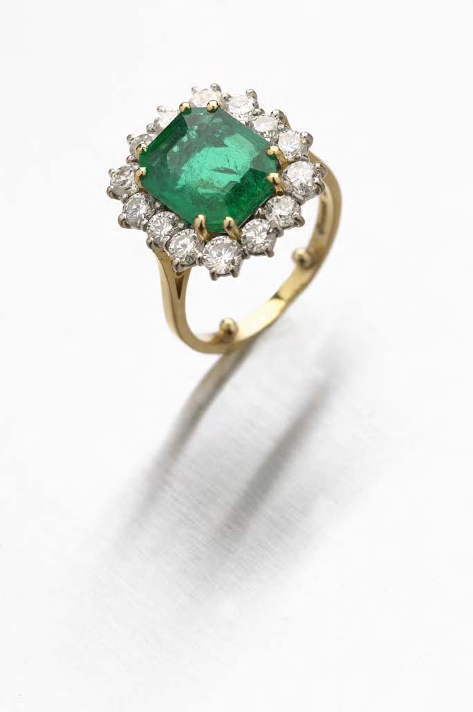 An 18ct gold mounted emerald and diamond cluster ring,