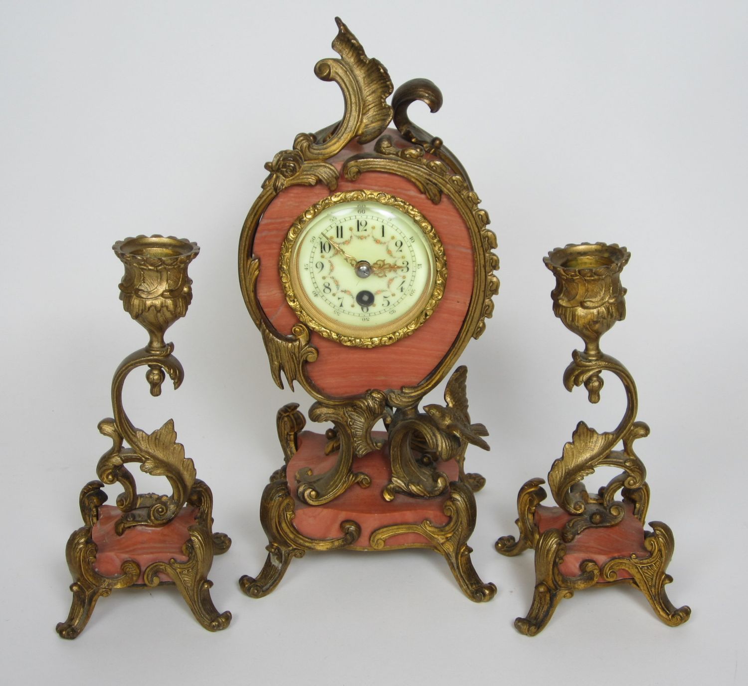 FRENCH PINK MARBLE AND GILT METAL MOUNTED CLOCK GARNITURE