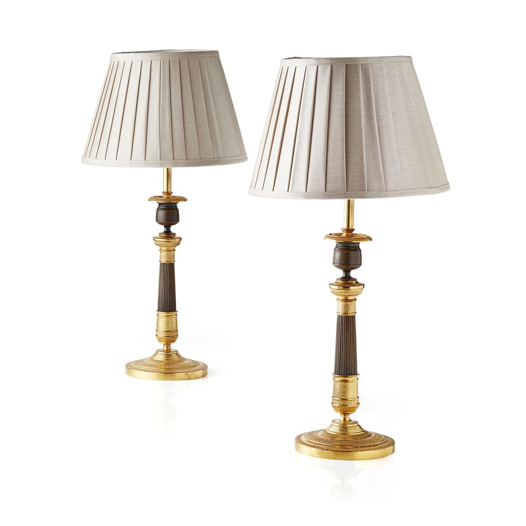 PAIR OF RESTAURATION PATINATED AND GILT METAL CANDLESTICKS