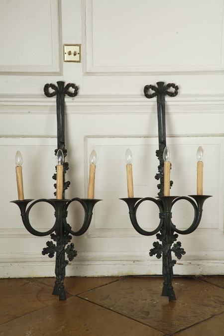 A pair of bronze three branch wall lights