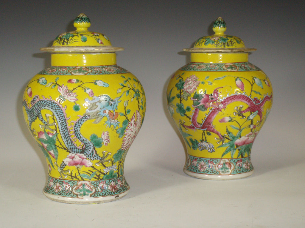 A pair of Chinese yellow ground famille rose jars and covers
